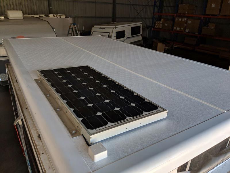 A Solar Panel Is Sitting On Top Of A White Van — Lake Macquarie Caravan Repairs In Cardiff, NSW