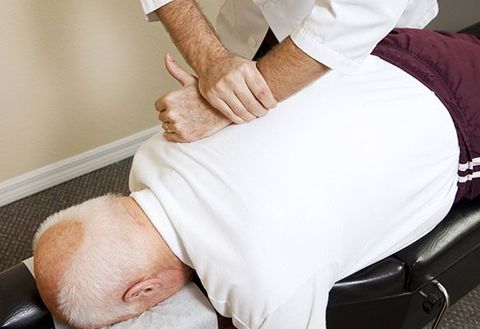Chiropractors Doing Spinal Adjustment on Senior Man — Manual Adjustments