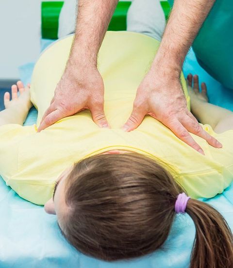 Chiropractor Performing Back Adjustment On Young Girl — Sacro-Occipital Technique