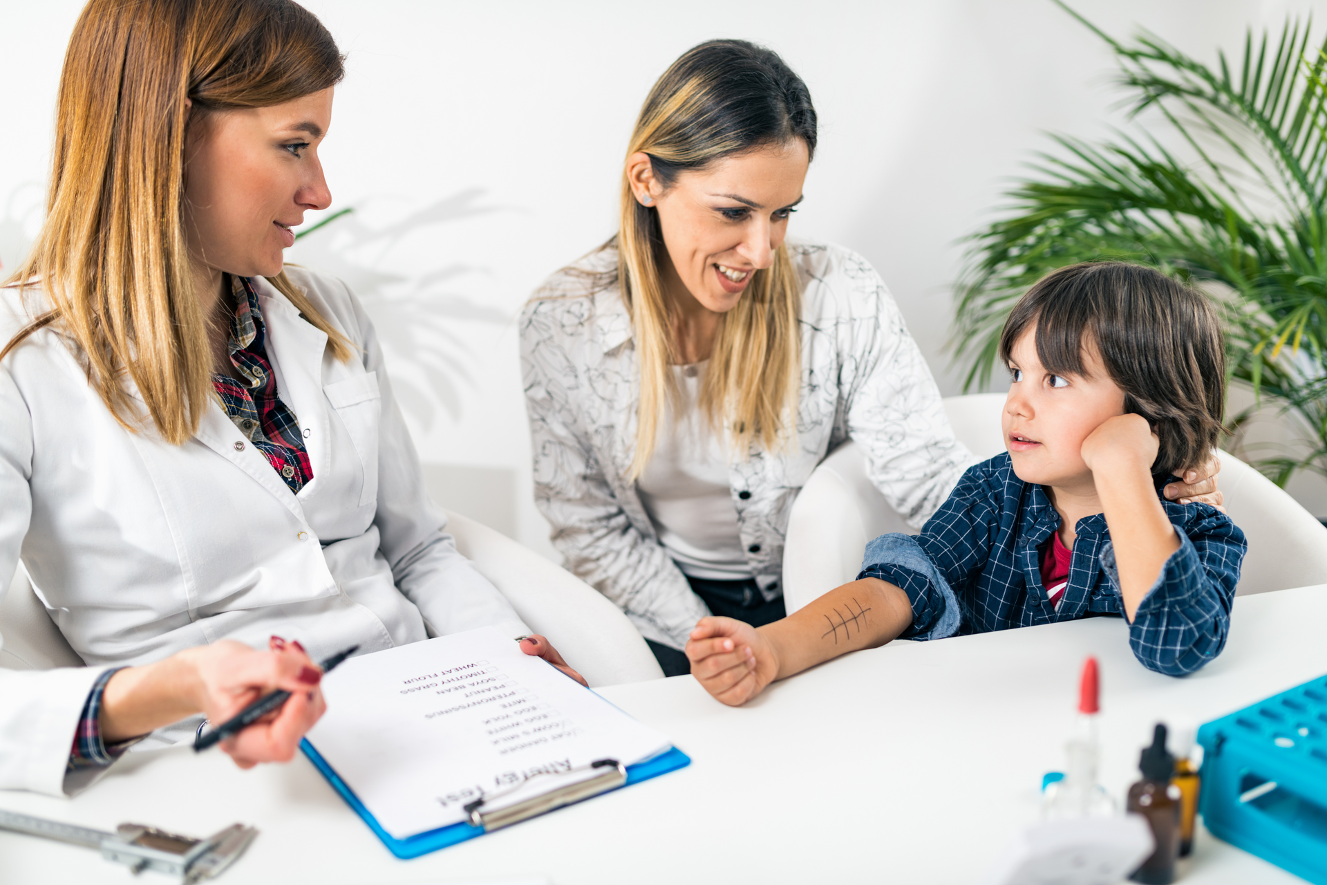 A woman is sitting at a table with a child and a woman.