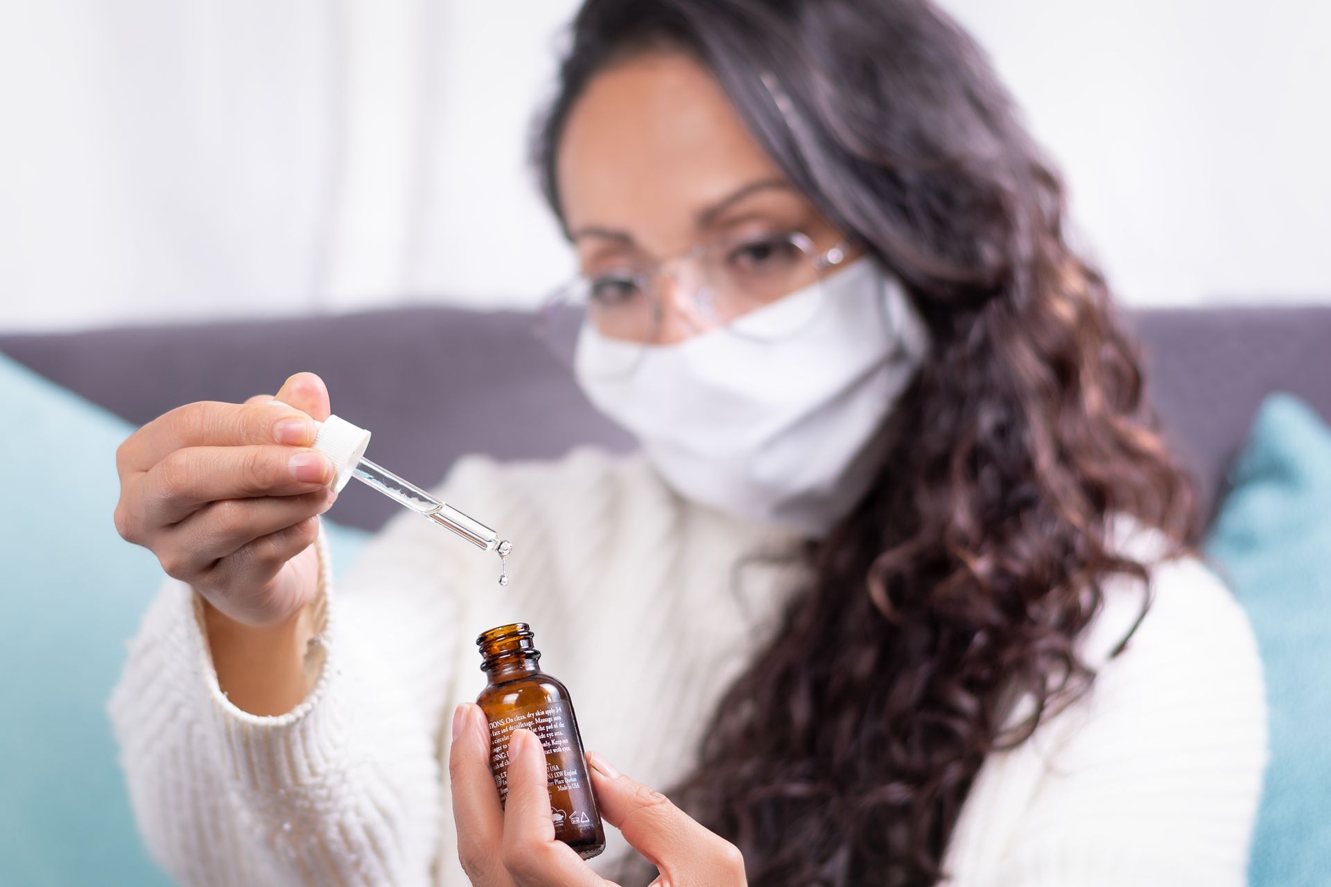 A woman using allergy drops to provide long-lasting relief against seasonal allergies.