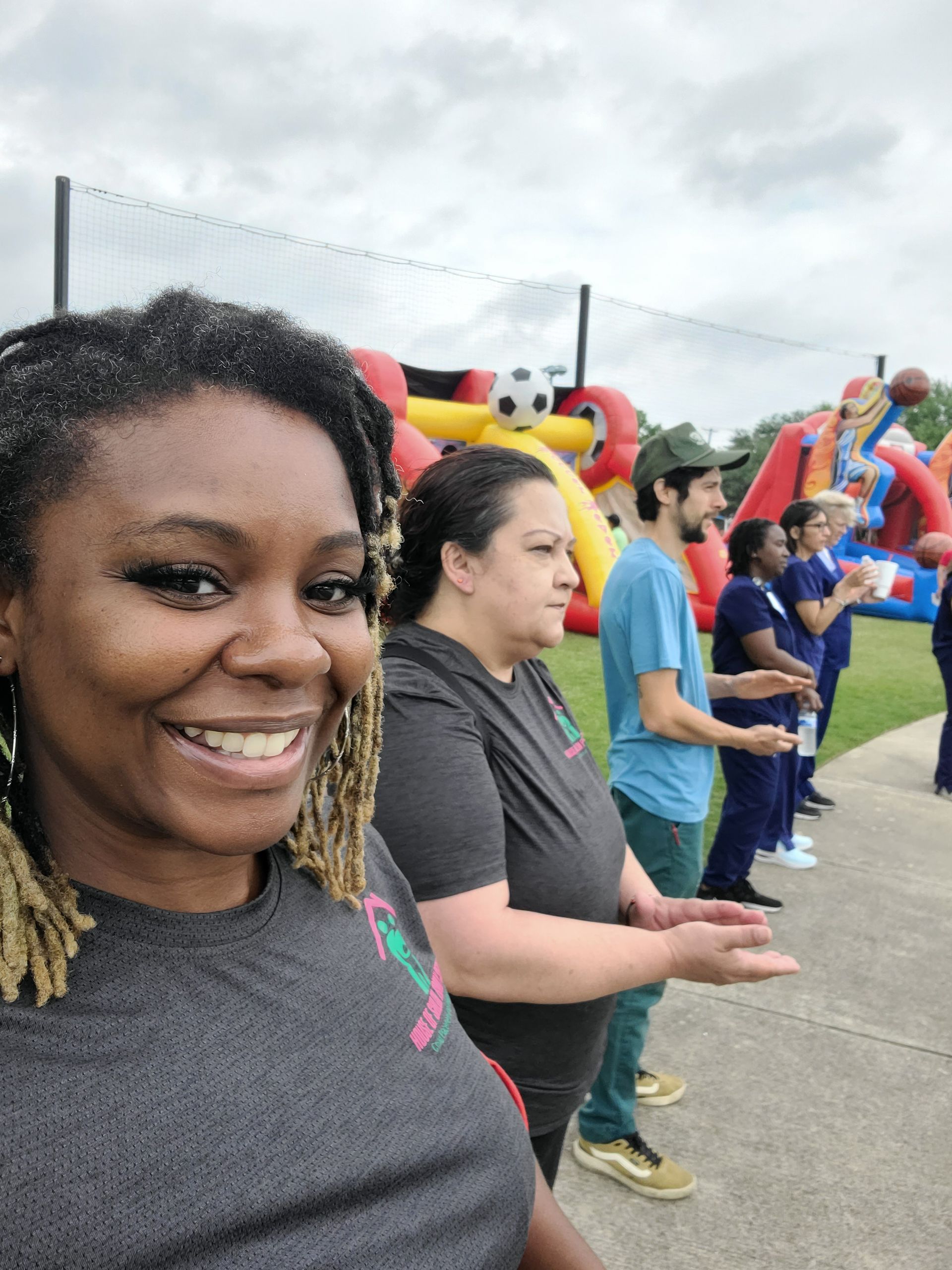 A group of people are standing in front of a bouncy house.