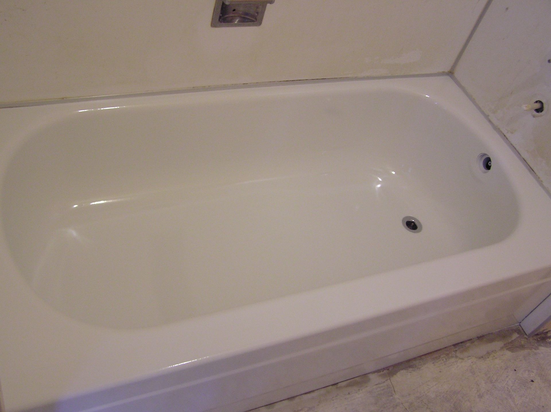 White bathtub in a room with unfinished walls.