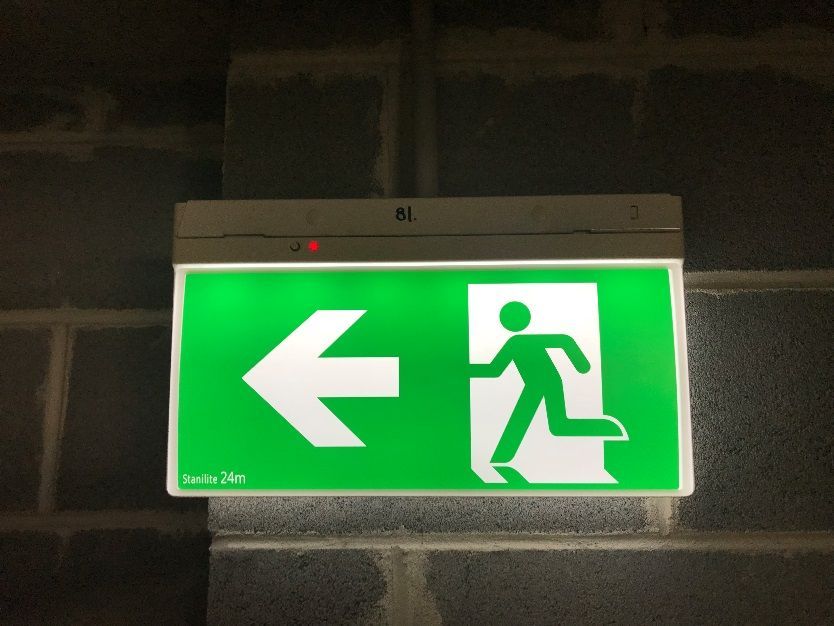 A green exit sign with an arrow pointing to the left