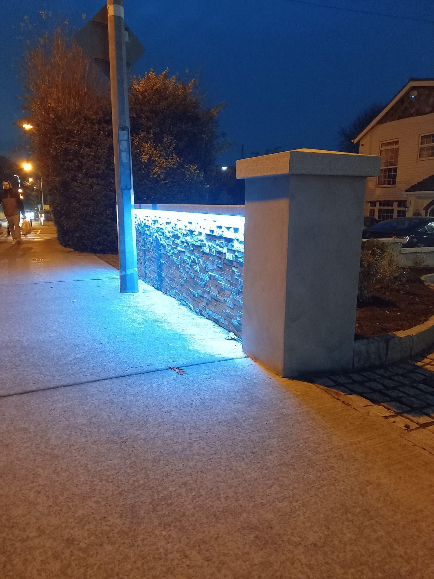 A brick wall with blue lights on it at night