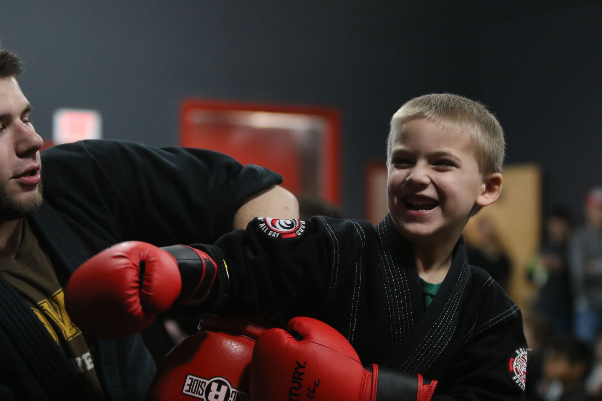 a young boy wearing red century boxing gloves