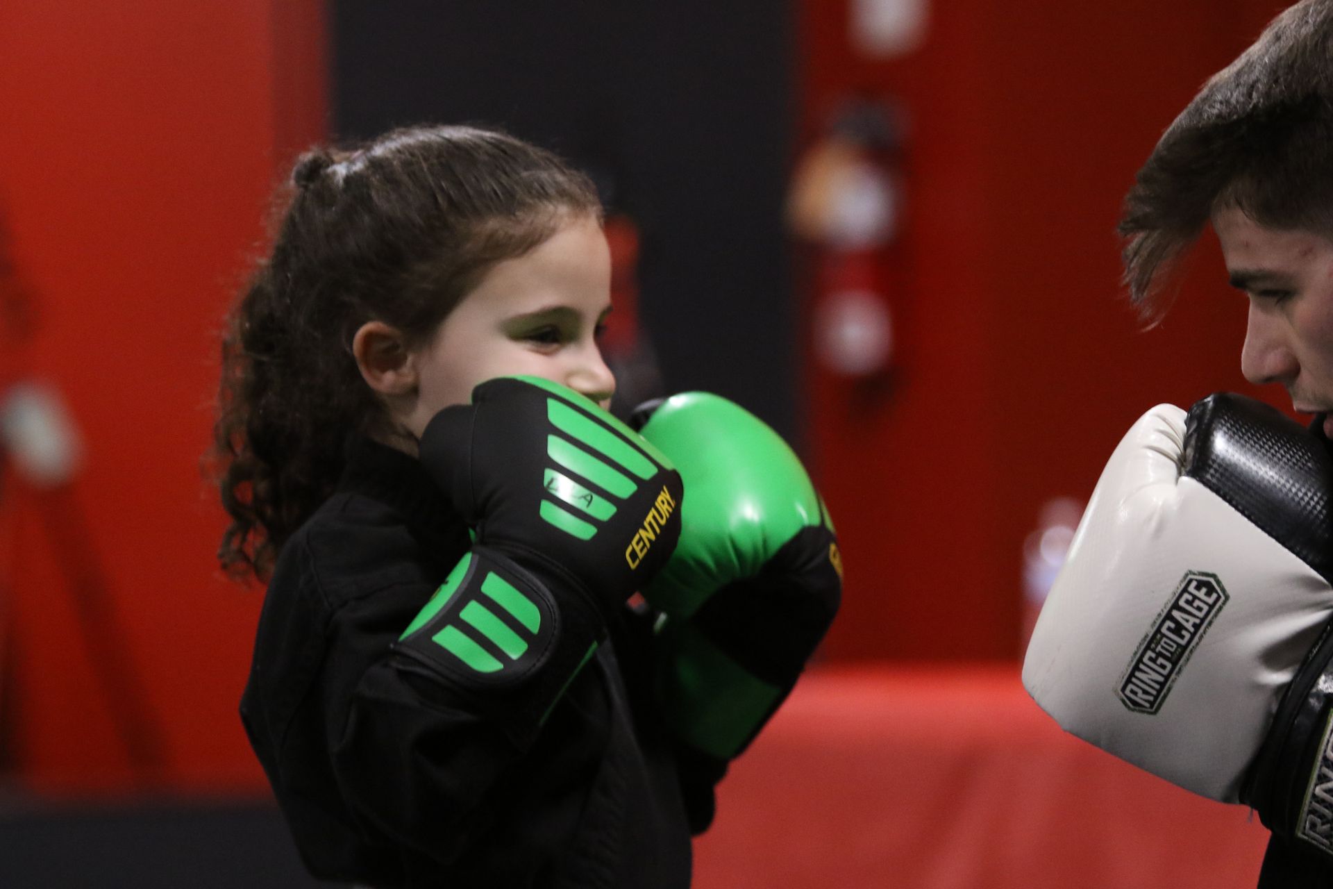 a young girl wearing green boxing gloves with the word centum on them