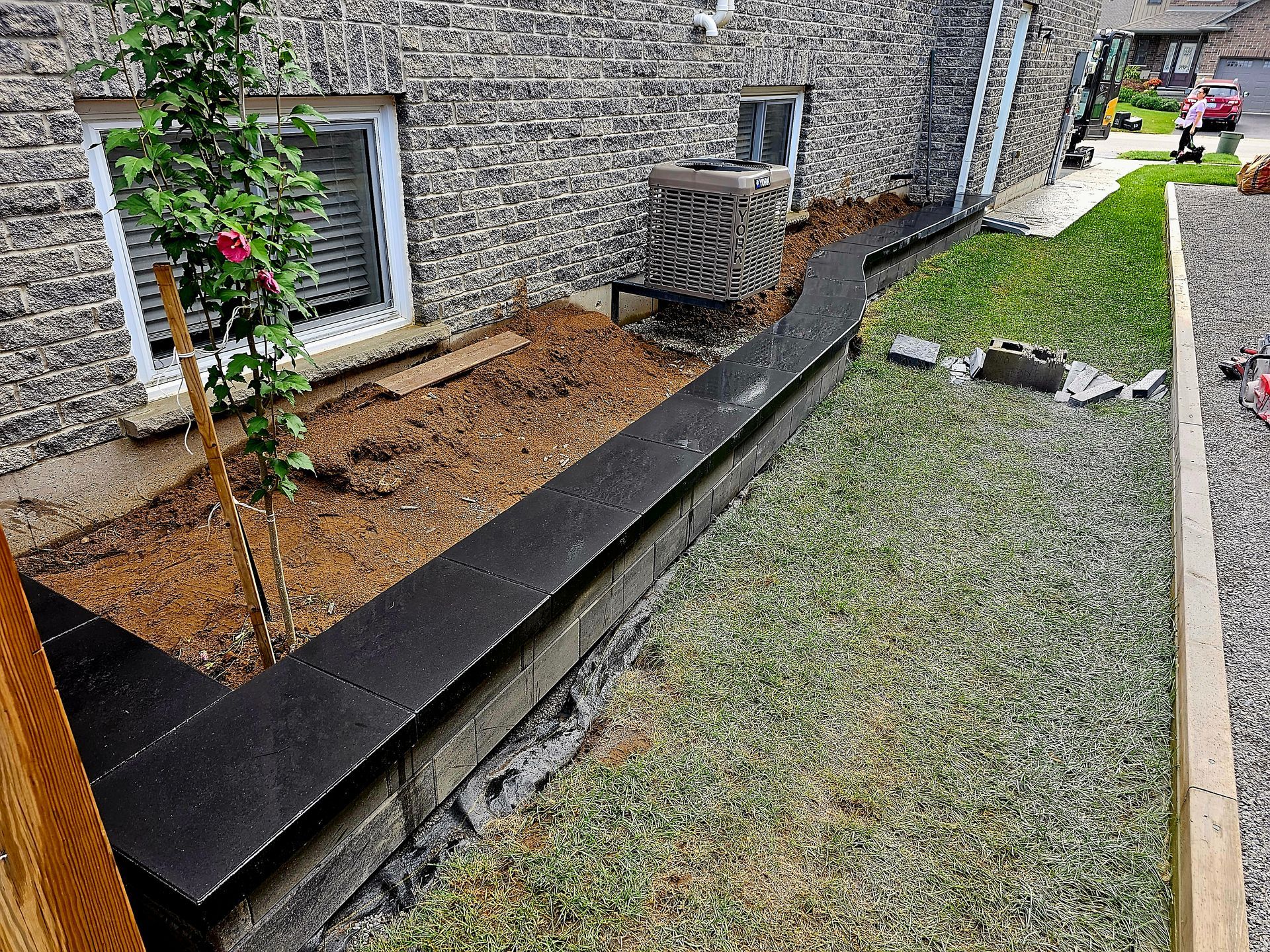 a sidewalk is being built in front of a brick house .