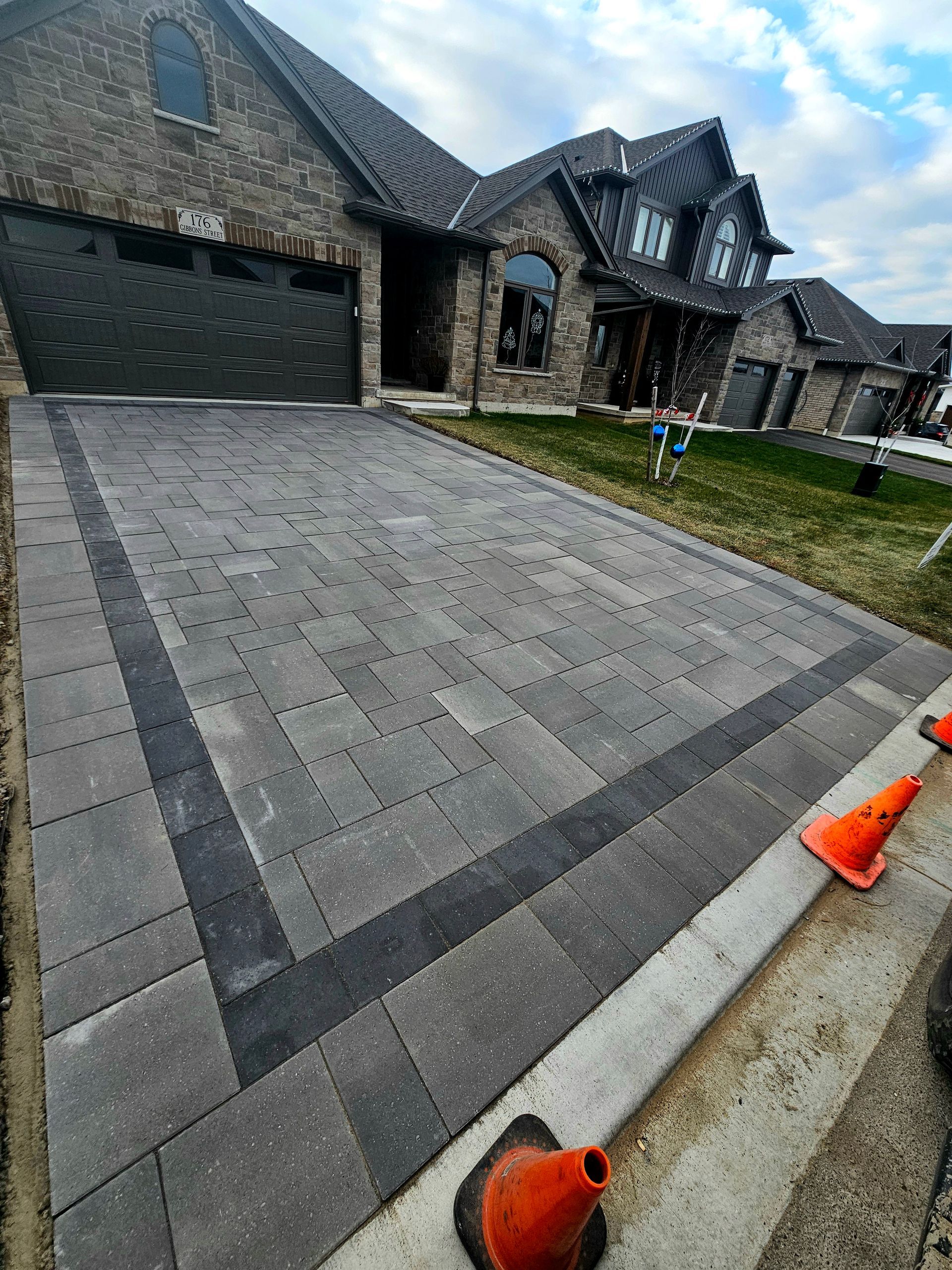 a brick driveway is being built in front of a large house .