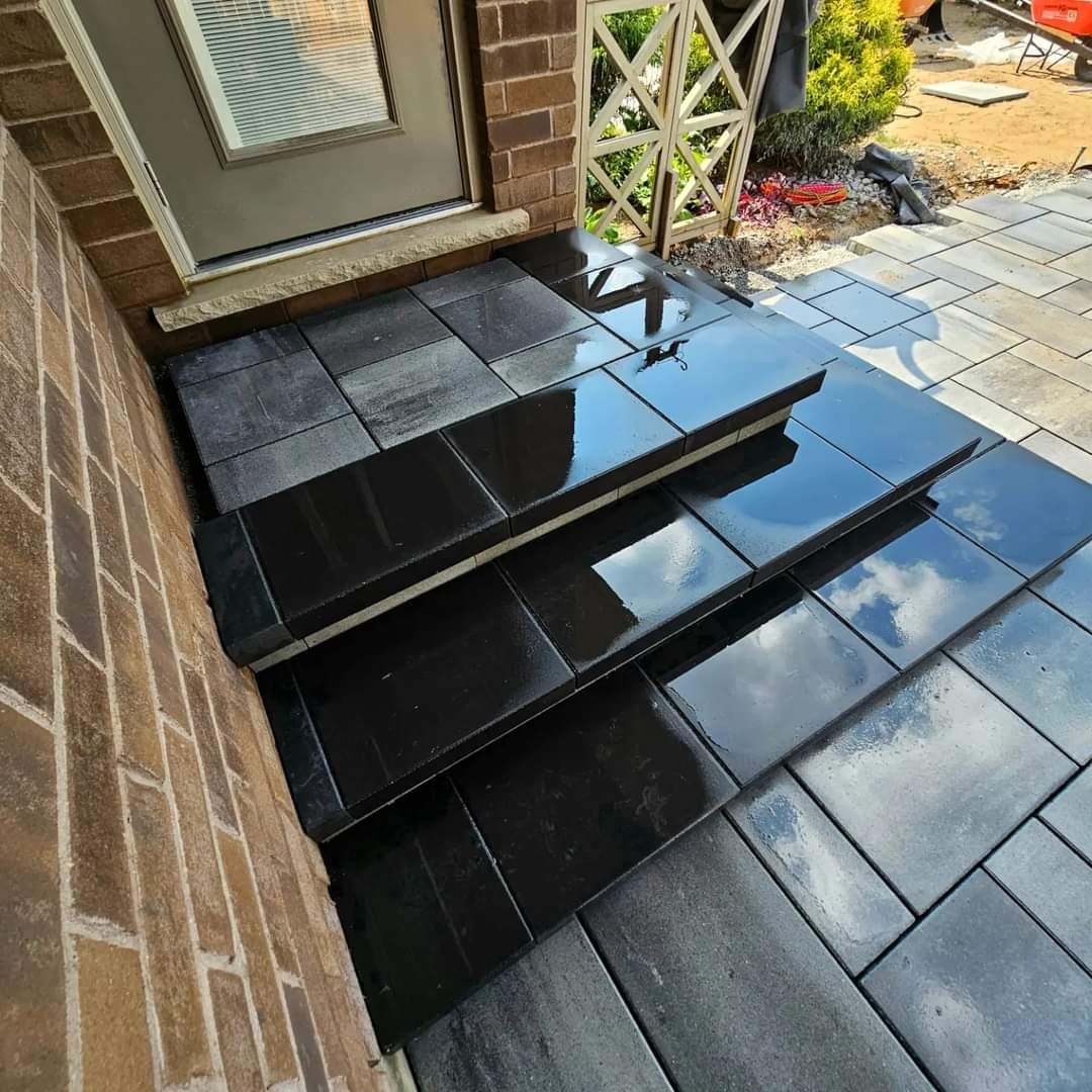 a set of black tiled steps leading up to a door .