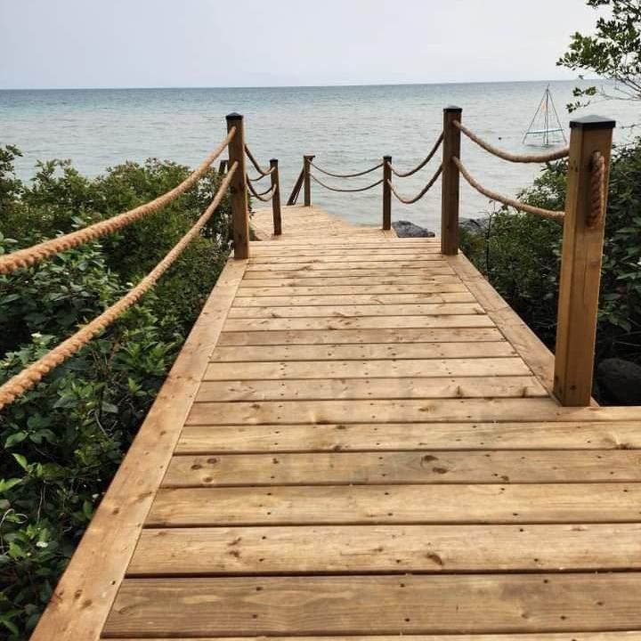 a wooden dock with ropes leading to the ocean