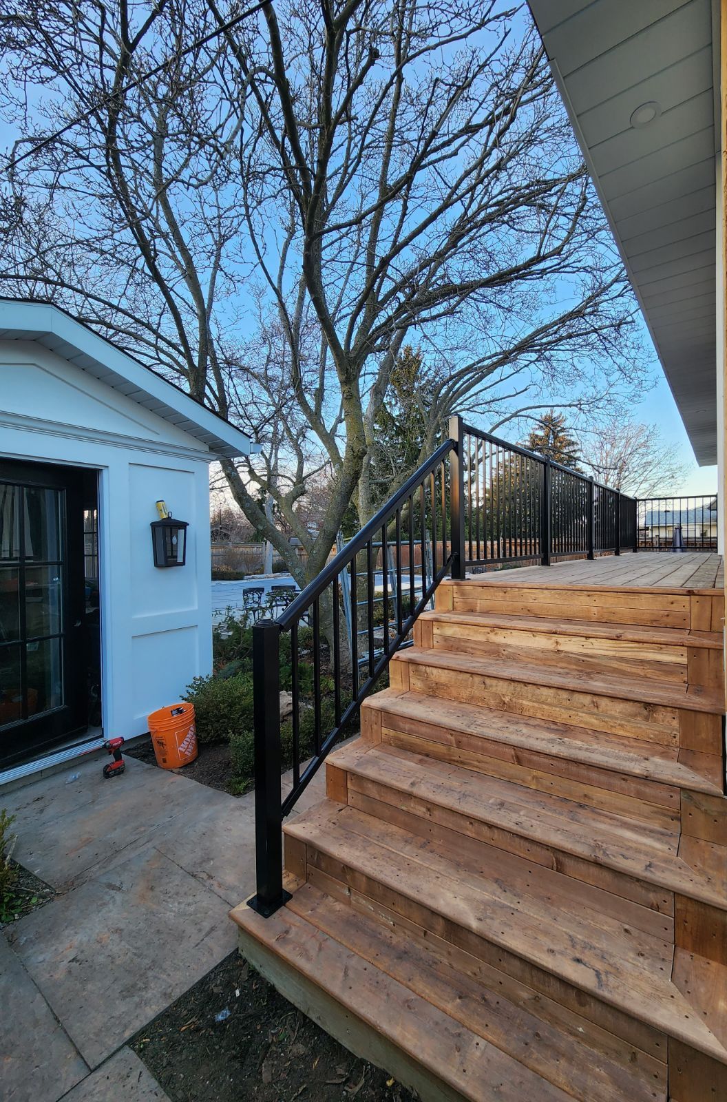 a wooden deck with stairs leading up to it and a metal railing .
