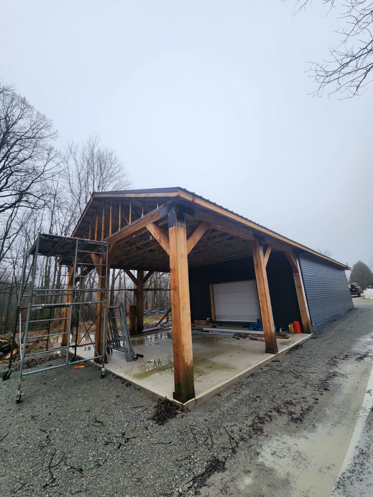 a wooden garage is being built next to a gravel road .