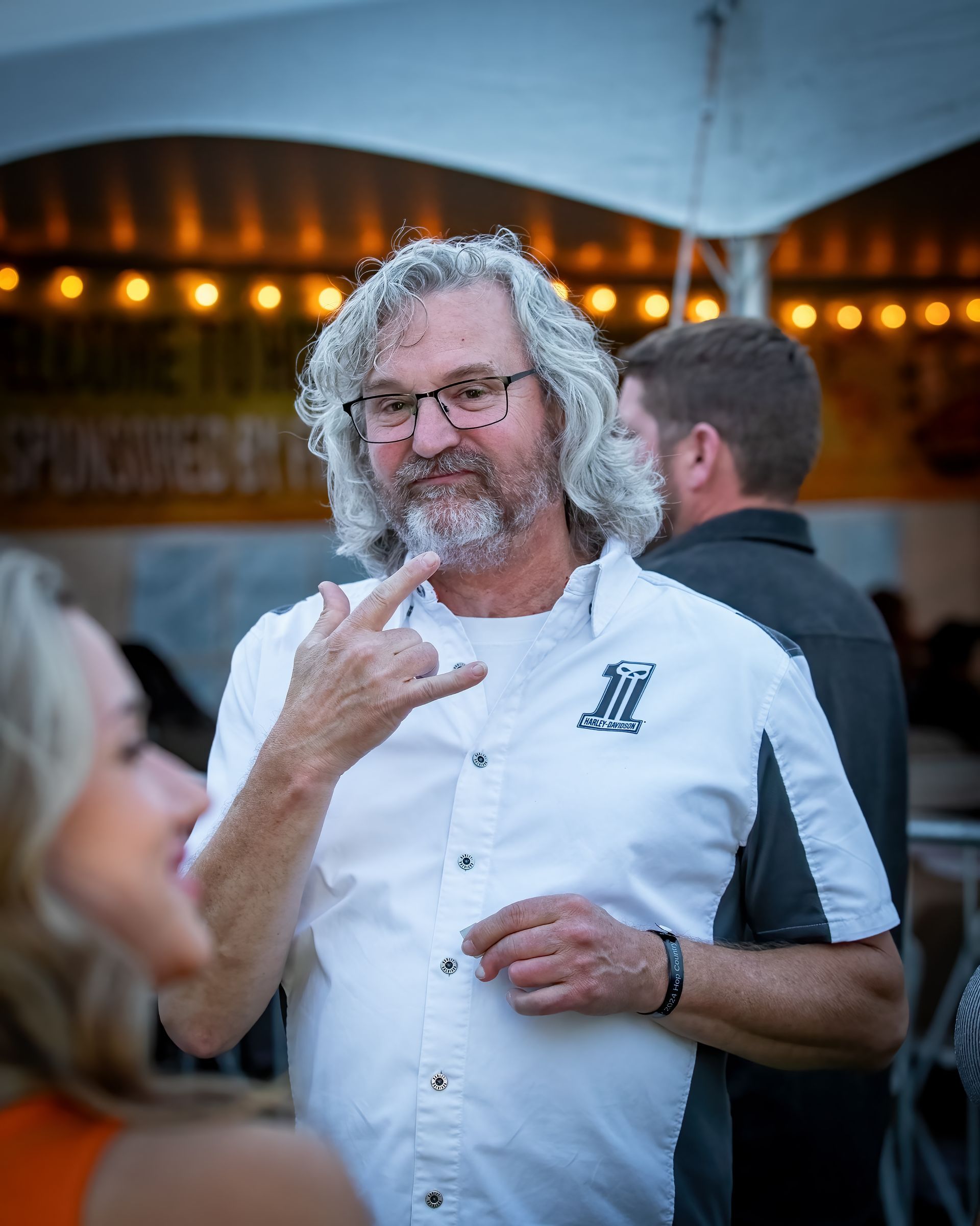 A man with glasses and a beard is talking to a woman.
