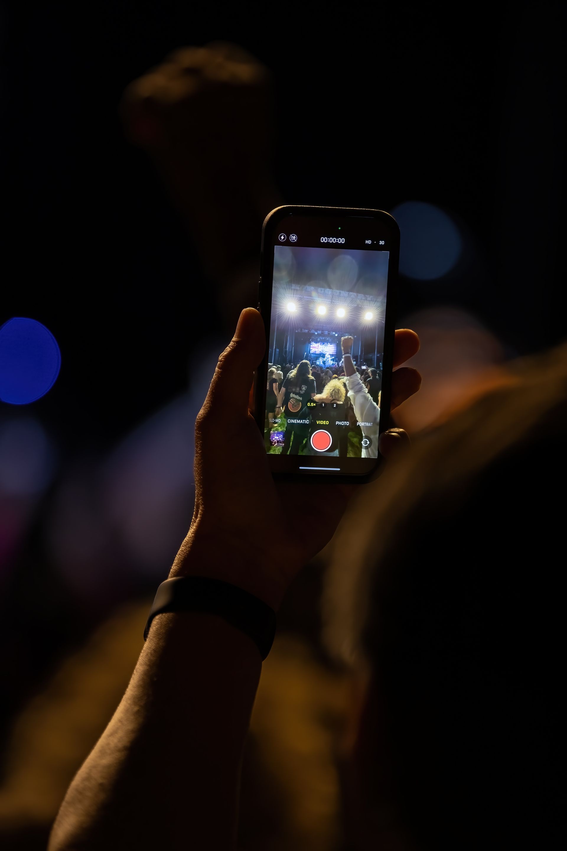 A person is taking a picture of a concert on their cell phone.