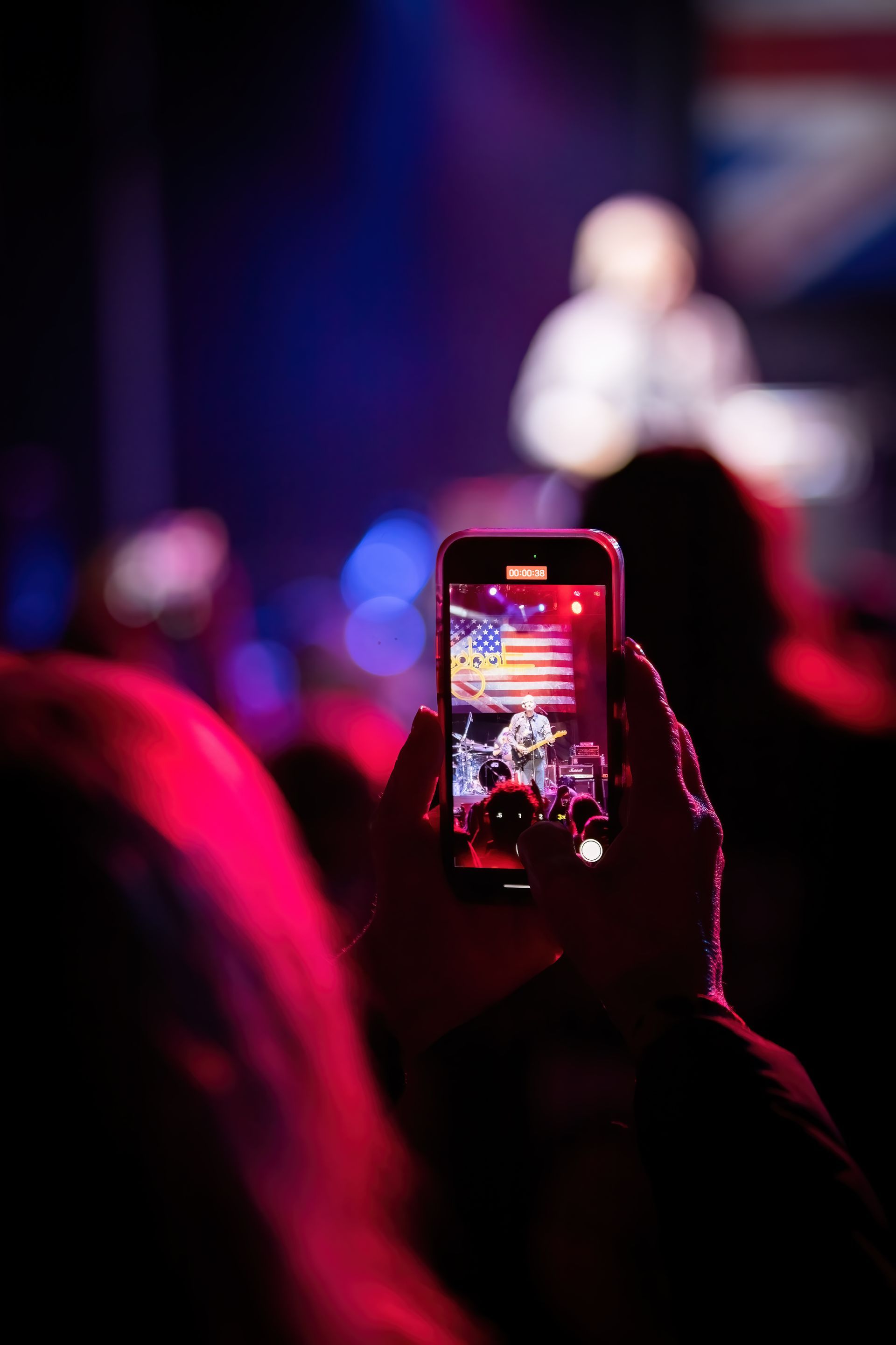 A person is taking a picture of a band on stage