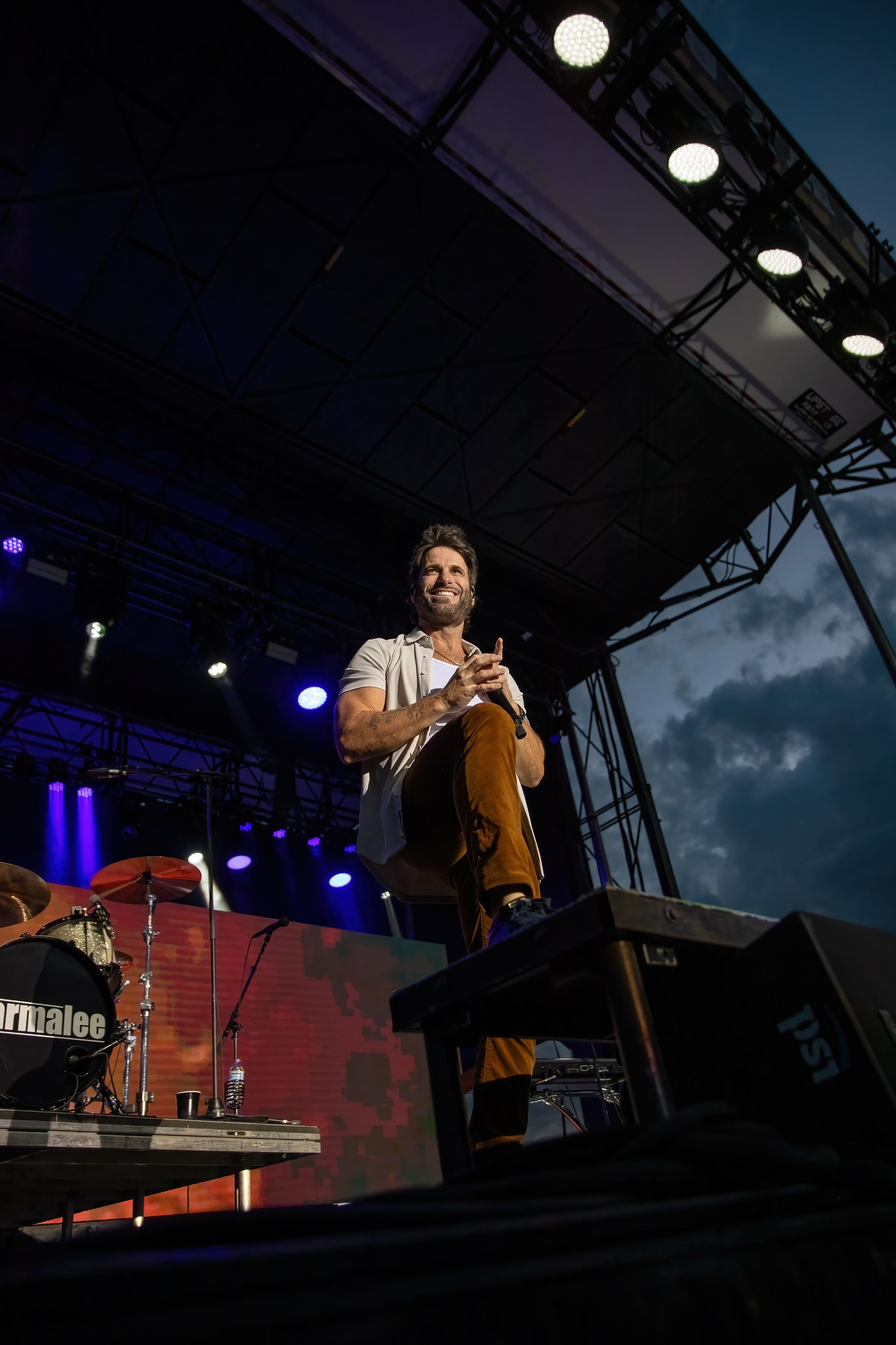 A man is playing a drum on a stage at a concert.