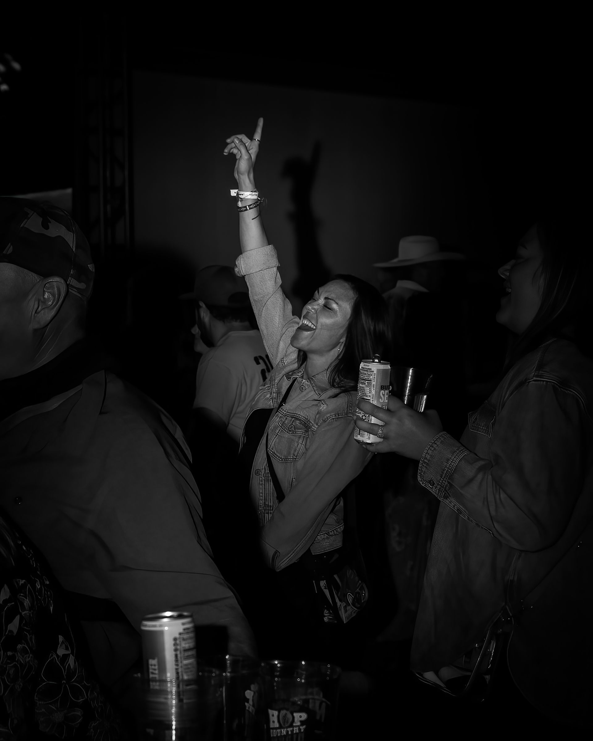 A black and white photo of a woman dancing in a club.
