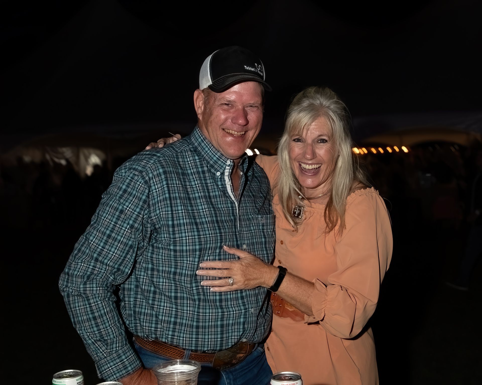 A man and a woman are posing for a picture at a party.