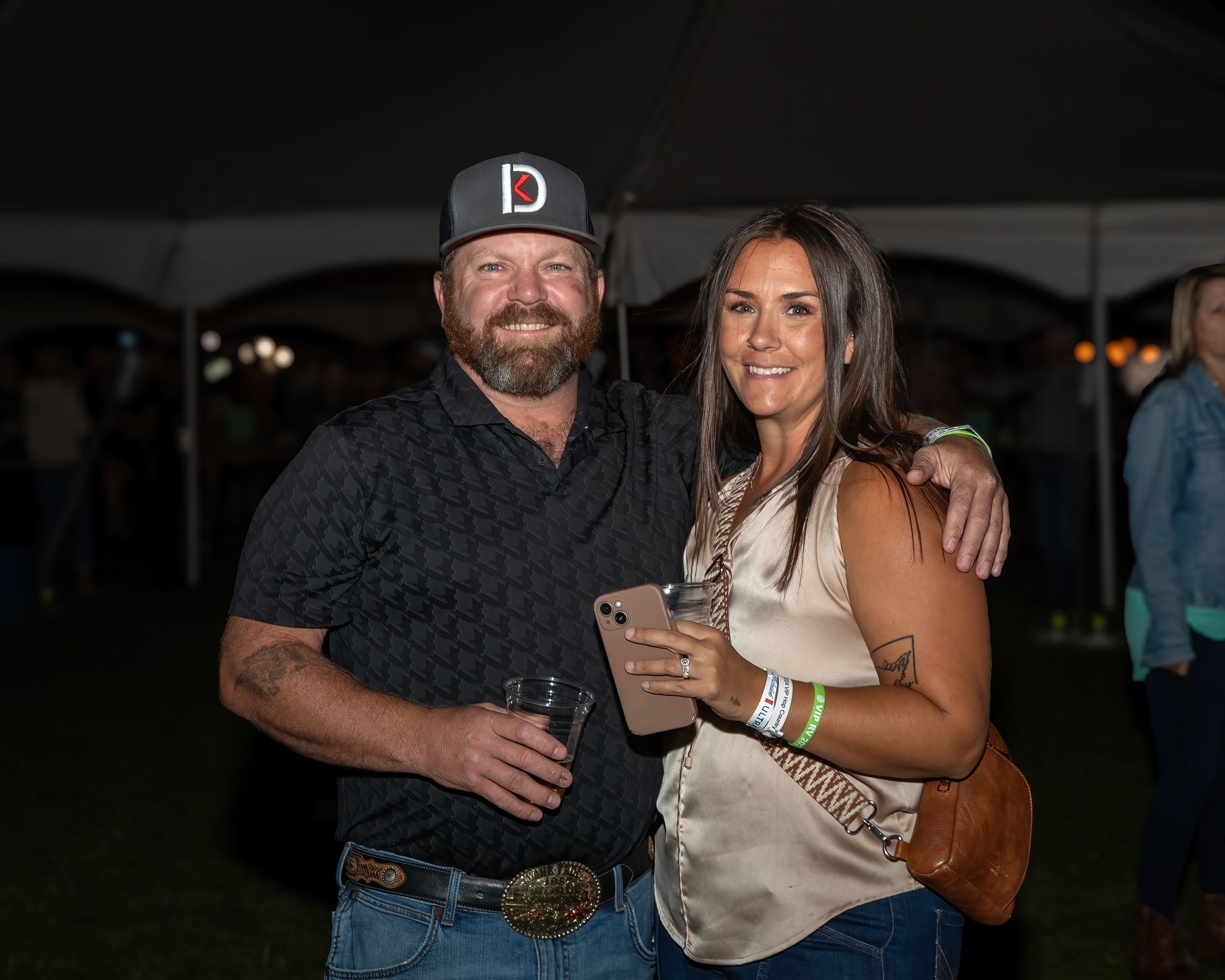 A man and a woman are posing for a picture in front of a tent.