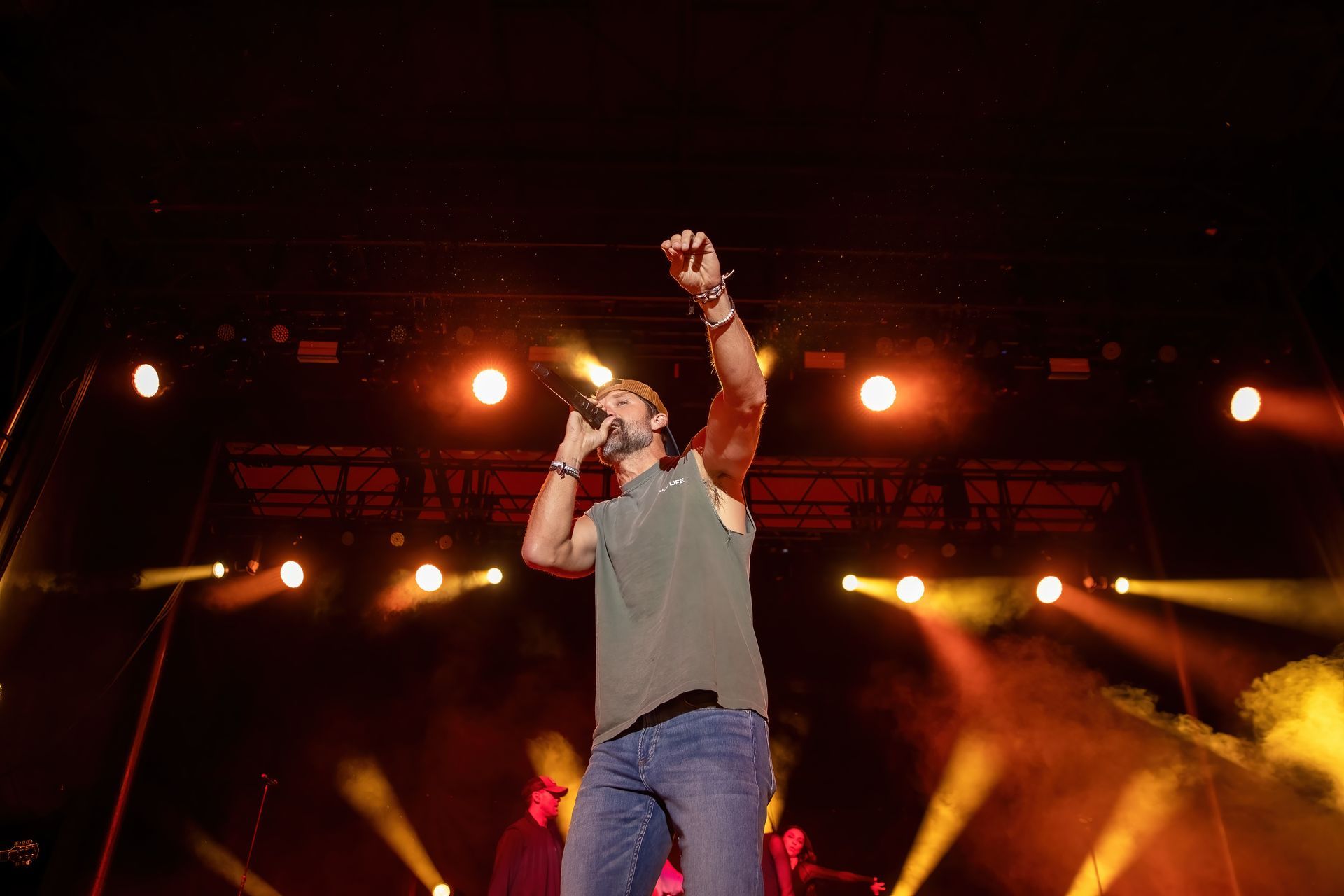 A man is singing into a microphone on a stage.