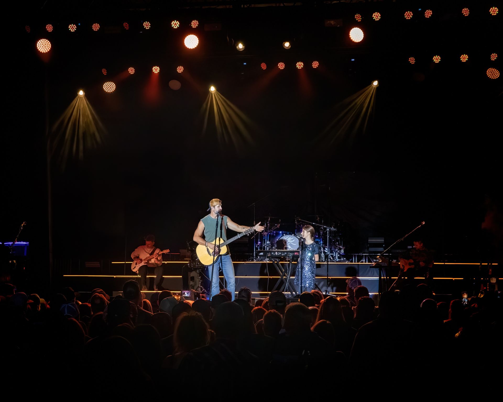 A man playing a guitar on stage in front of a crowd