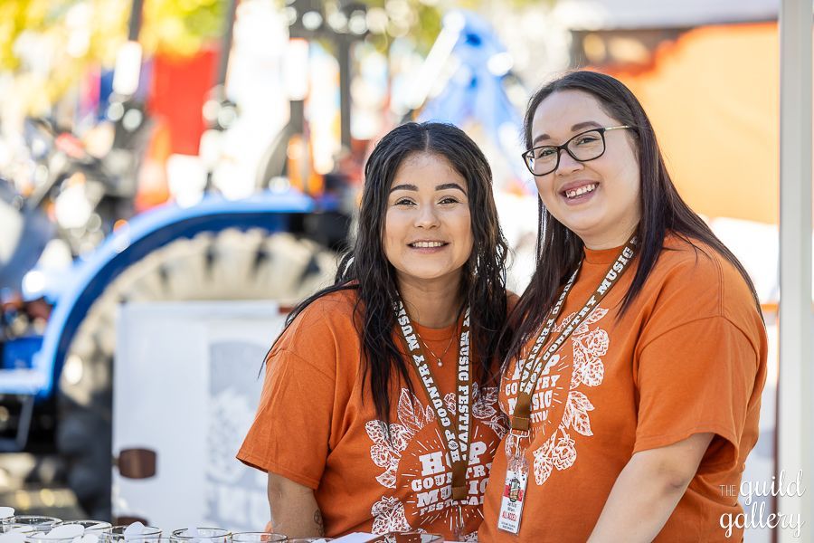 Two women are standing next to each other and smiling for the camera.