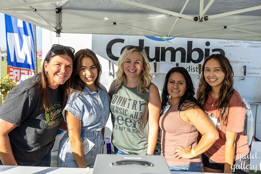 A group of women are posing for a picture in front of a tent.