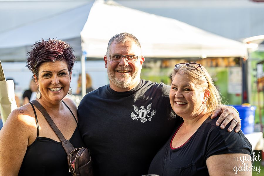 A man and two women are posing for a picture together.