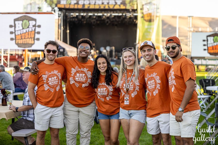 A group of people are posing for a picture at a music festival.