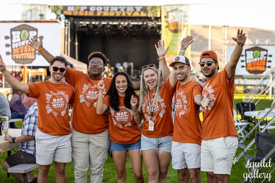 A group of people are posing for a picture at a music festival.