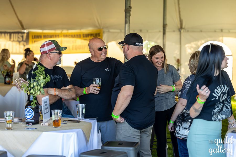 A group of people are standing around a table in a tent.