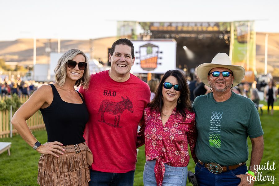 A group of people are posing for a picture at a concert.