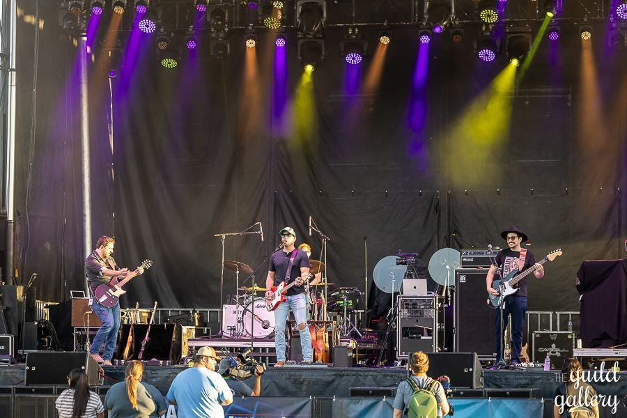 A group of men are playing guitars on a stage.