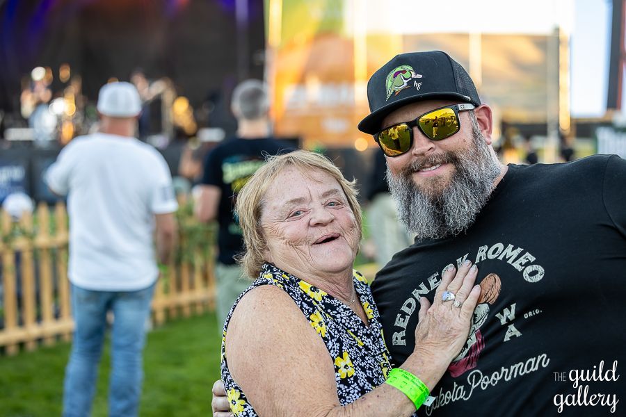 A man and a woman are posing for a picture at a concert.