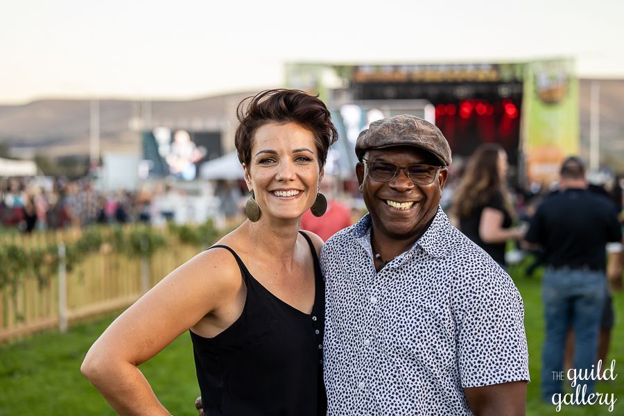 A man and a woman are posing for a picture at a concert.
