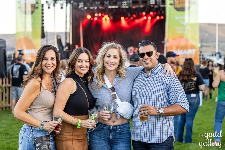 A group of people are posing for a picture at a concert.