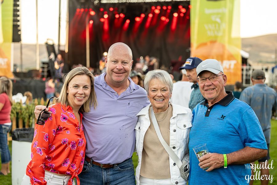 A group of people are posing for a picture at a concert.