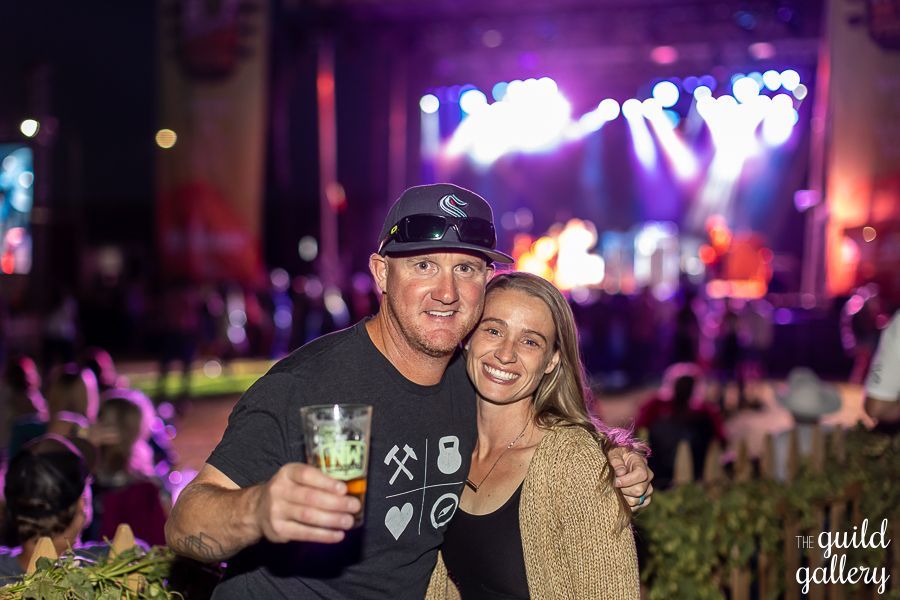 A man and a woman are posing for a picture at a concert.