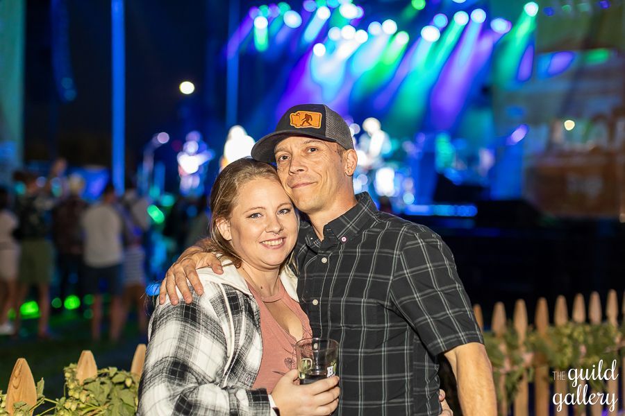 A man and a woman are posing for a picture at a concert.