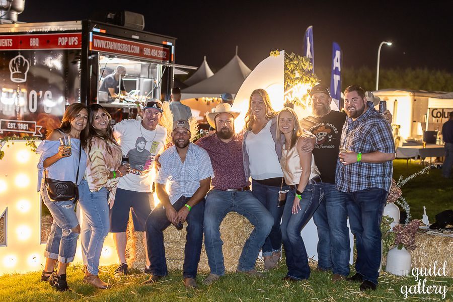 A group of people are posing for a picture in front of a food truck.