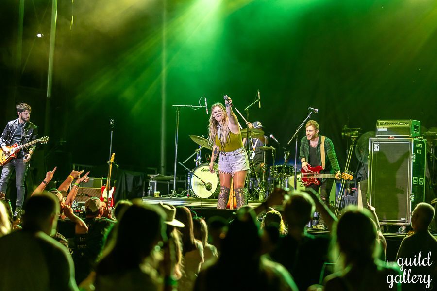 A group of people are playing instruments on a stage in front of a crowd.
