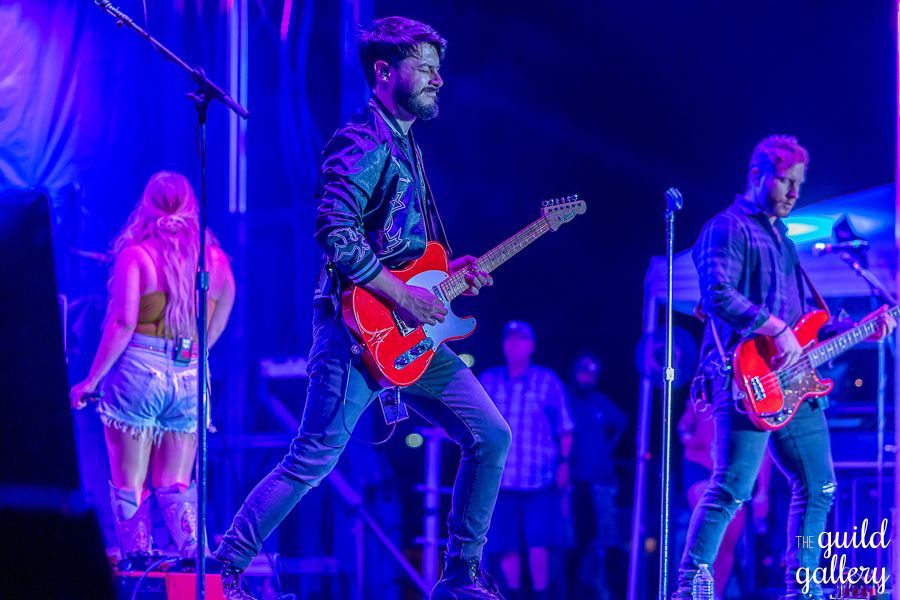 A group of people are playing guitars on a stage.