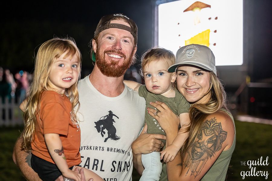 A man , woman , and two children are posing for a picture.