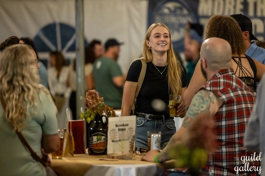 A group of people are sitting around a table at a festival.