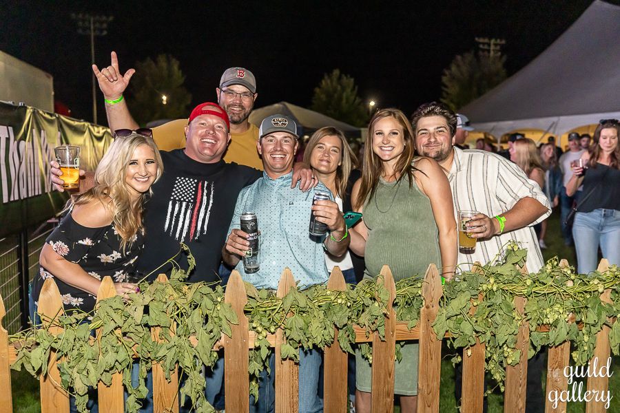 A group of people are posing for a picture behind a wooden fence.