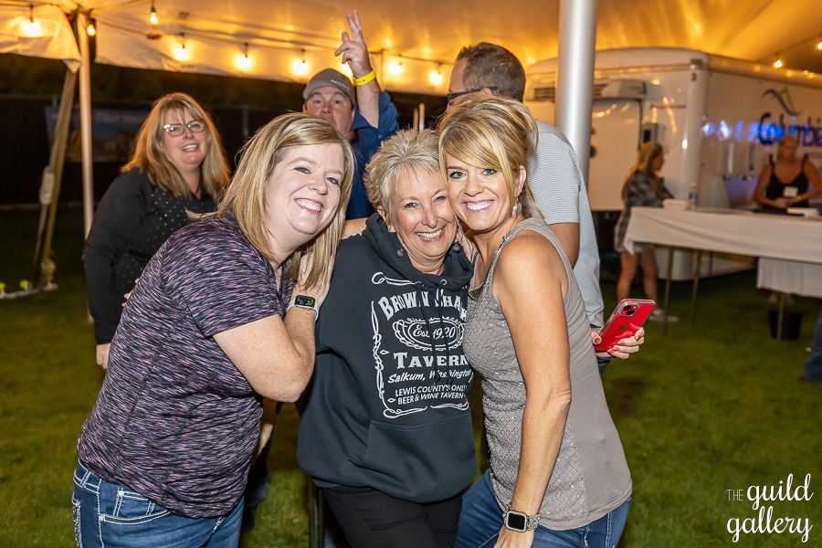 A group of women are posing for a picture under a tent.