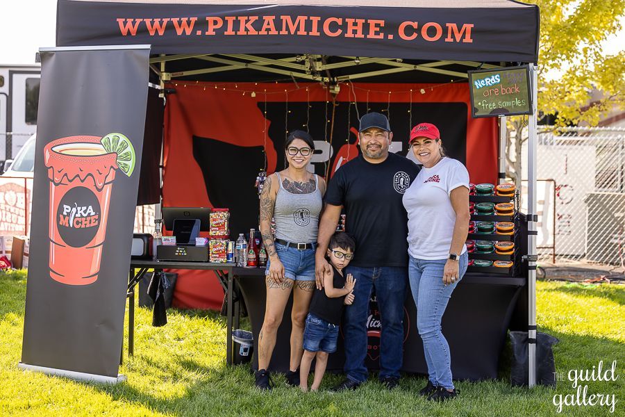 A group of people standing in front of a food stand.