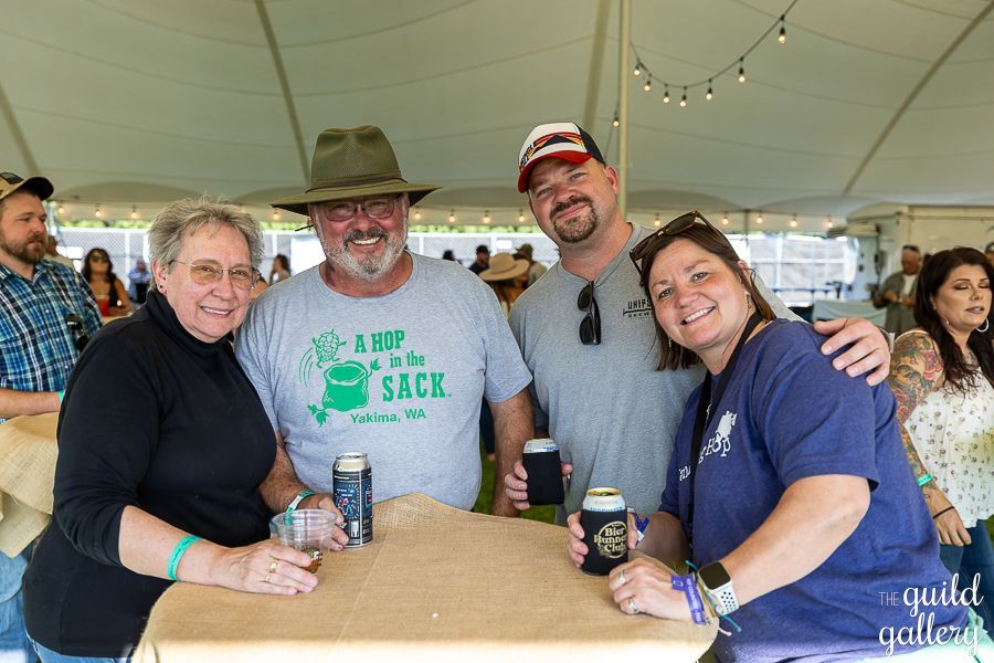 A group of people are posing for a picture while sitting at a table.