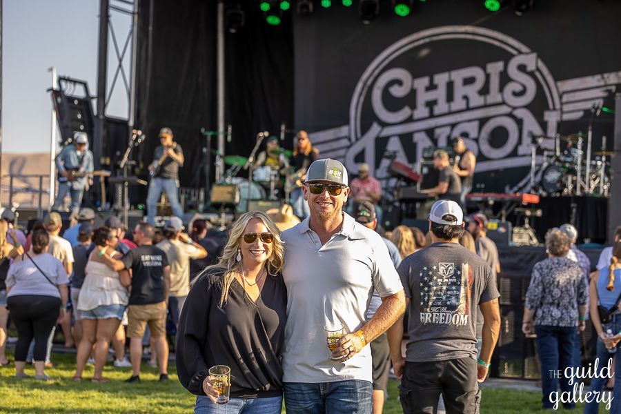A man and a woman are posing for a picture in front of a crowd at a concert.
